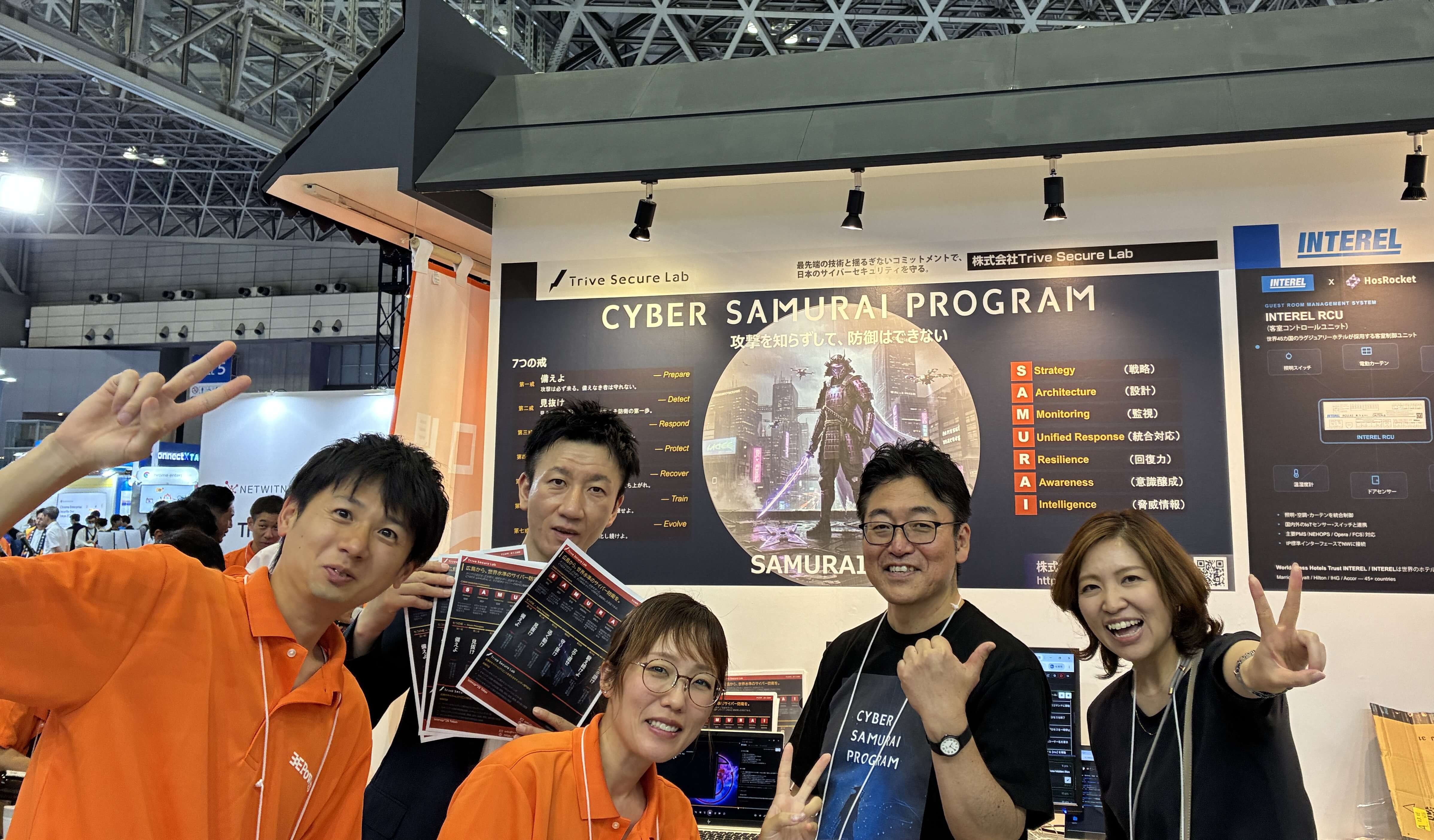 TSLブースでのTrive社員との集合写真